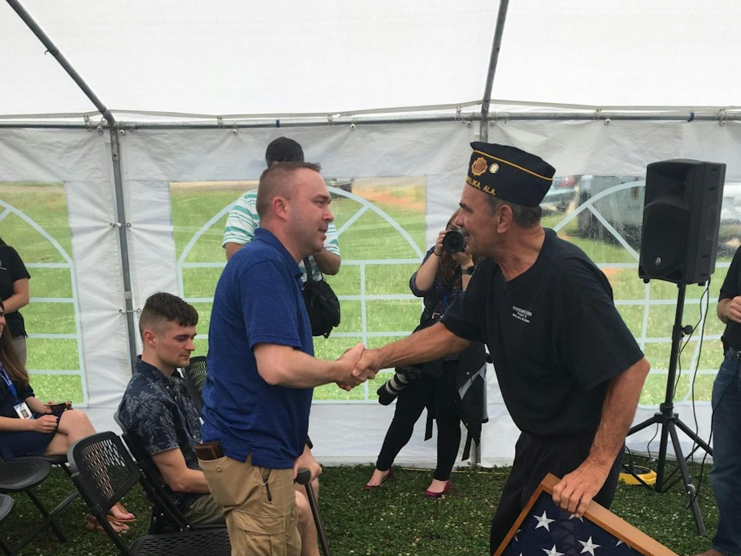 Retired Sgt. Adam Lee shakes hands with a representative from American Legion as he presents Lee with&nbsp;a plaque of appreciation Wednesday, May 30, 2018.&nbsp;