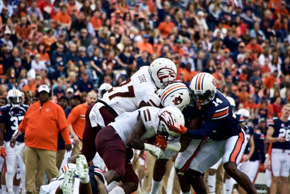 Stephen Roberts (14) and Nick Ruffin (19)&nbsp;stop a ULM ball&nbsp;carrier&nbsp;in his tracks during&nbsp;during Auburn vs ULM on Saturday, Nov. 18 in Auburn, Ala.