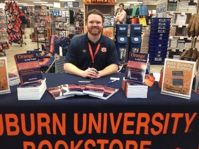 Auburn alumnus Josh Dowdy signs copies of his new book, Orange Is Our Color.