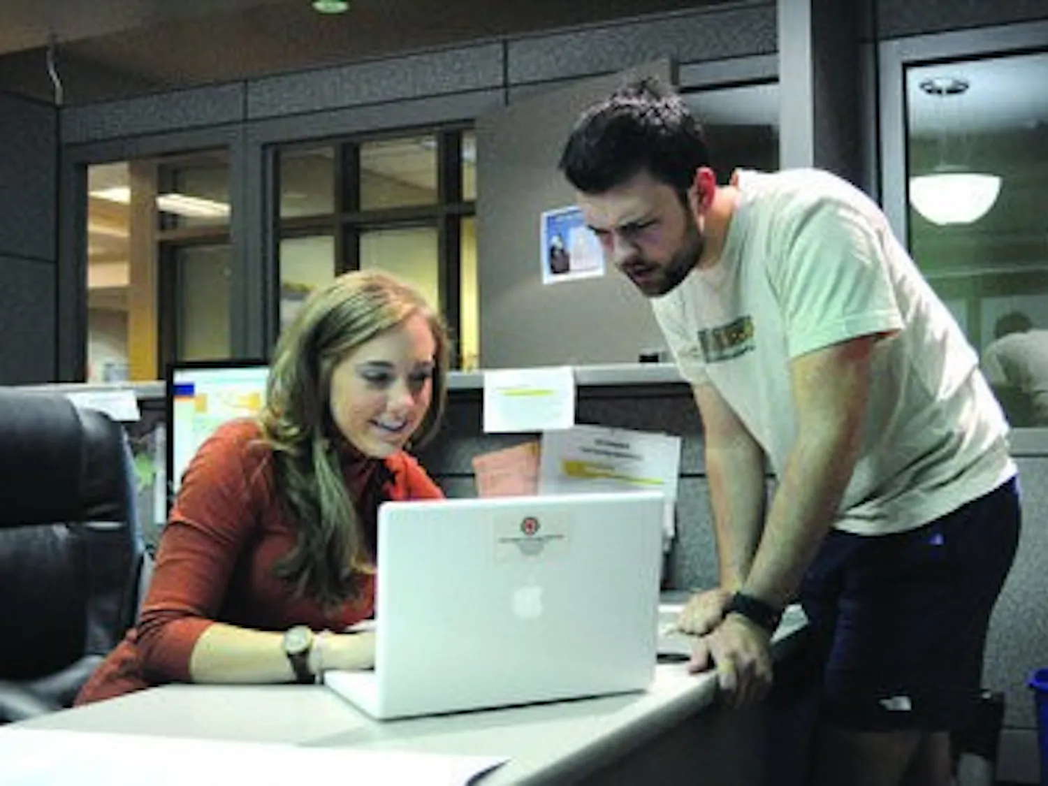 Allison Chandler, IT specialist, takes a look at the computer of Tyler Claxton, junior in forestry. (Christen Harned / ASSISTANT PHOTO EDITOR)