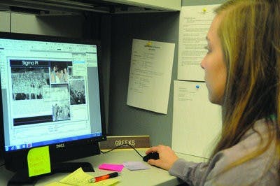 Hilary Johnson, junior in radio, television and film and managing editor for the Glomerata, looks over pages of the yearbook. The Glom will spend $192,500 of its budget this year to print color pages. (Christen Harned / ASSISTANT PHOTO EDITOR)