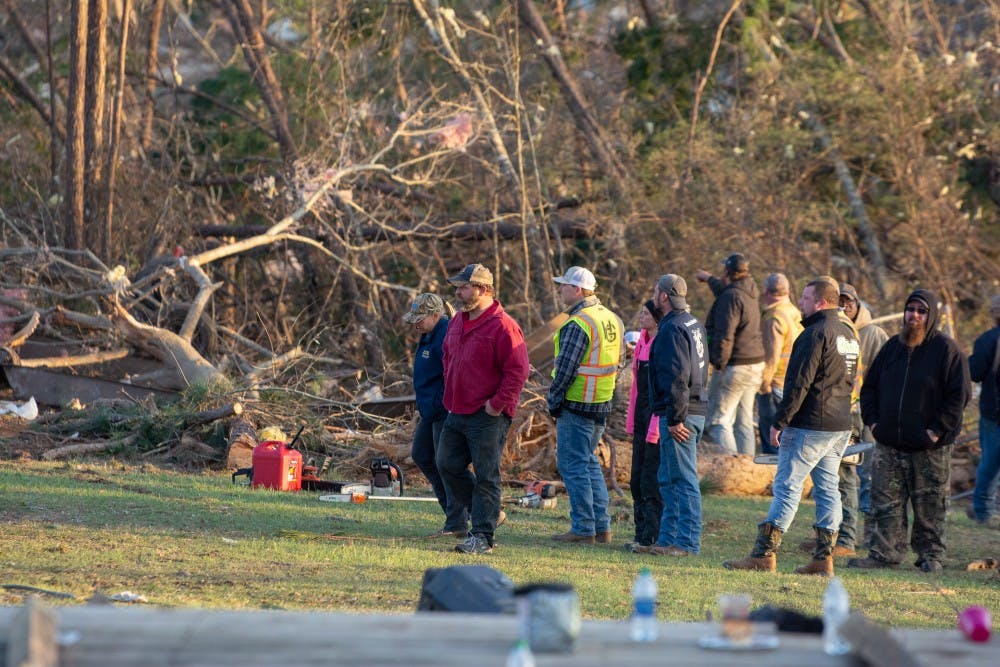 Residents and first responders stand together on March 4, 2019, alongside the wreckage of a home completely destroyed by a tornado that killed 23 people in Beauregard, Alabama, the previous day.