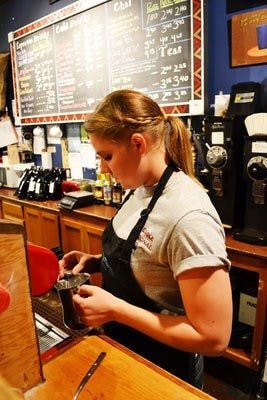 Meredith Harbison, a barista at Toomer's Coffee, makes coffee for a customer Wednesday. The coffee shop, located on South College, is for sale after seven years of business so owners Sandy and Trish Toomer can pursue other life dreams. (Danielle Lowe / ASSISTANT PHOTO EDITOR)