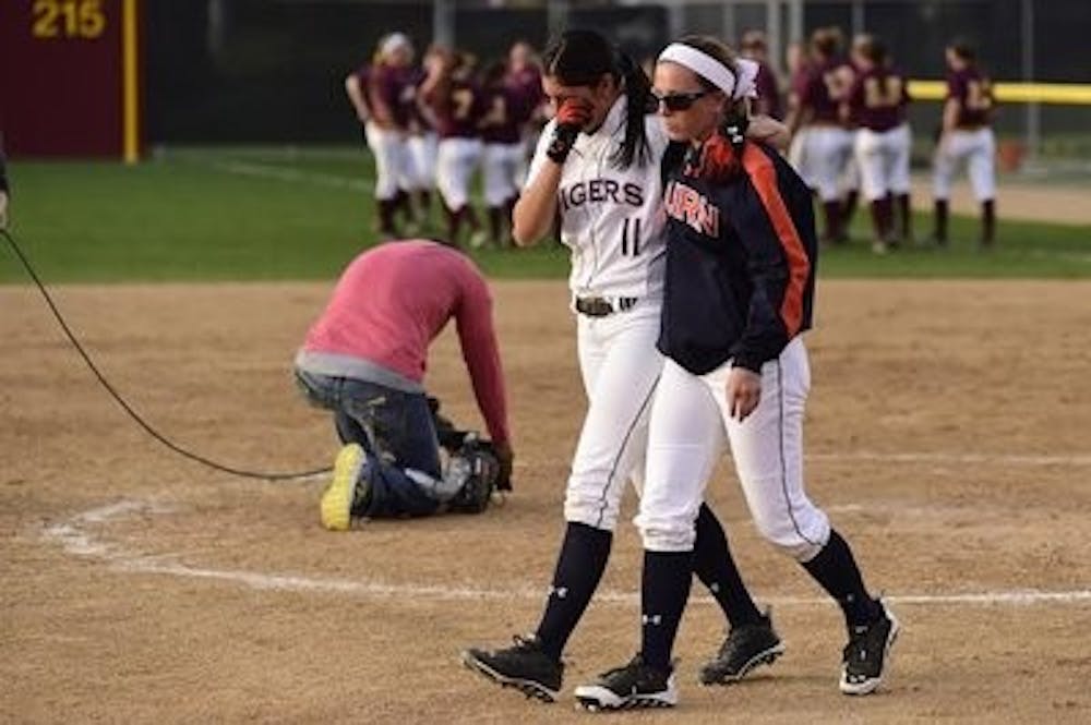 Seniors Maris Medina (11) and Kristyn Richards (7) walk off the field after the loss. Minnesota vs Auburn in the NCAA Softball Tournament Regional in Minneapolis, Minn., on Sunday, May 18, 2014. (Zach Bland / Auburn Athletics)