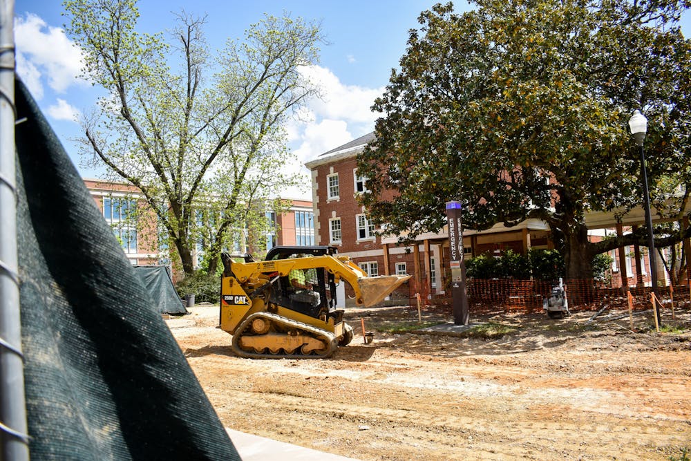 A bulldozer lifts dirt into its blade as construction continues on Auburn University's quad dorm rooms on April 25, 2022.
