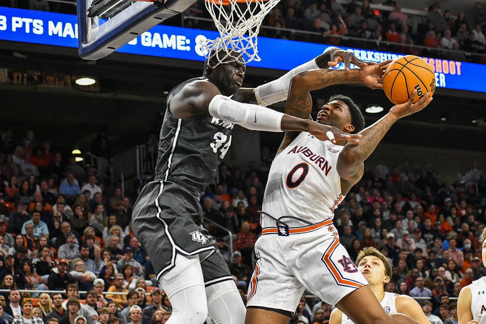 Dec. 1, 2021; Auburn, Alabama; K.D. Johnson (0) fights through contact at the rim in a match between Auburn and UCF in the Auburn Arena.