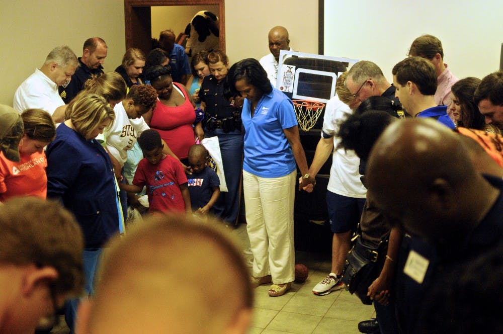 Members of the Auburn community join hands in prayer at National Night Out on Tuesday, August 2, 2016 in Auburn, Ala.