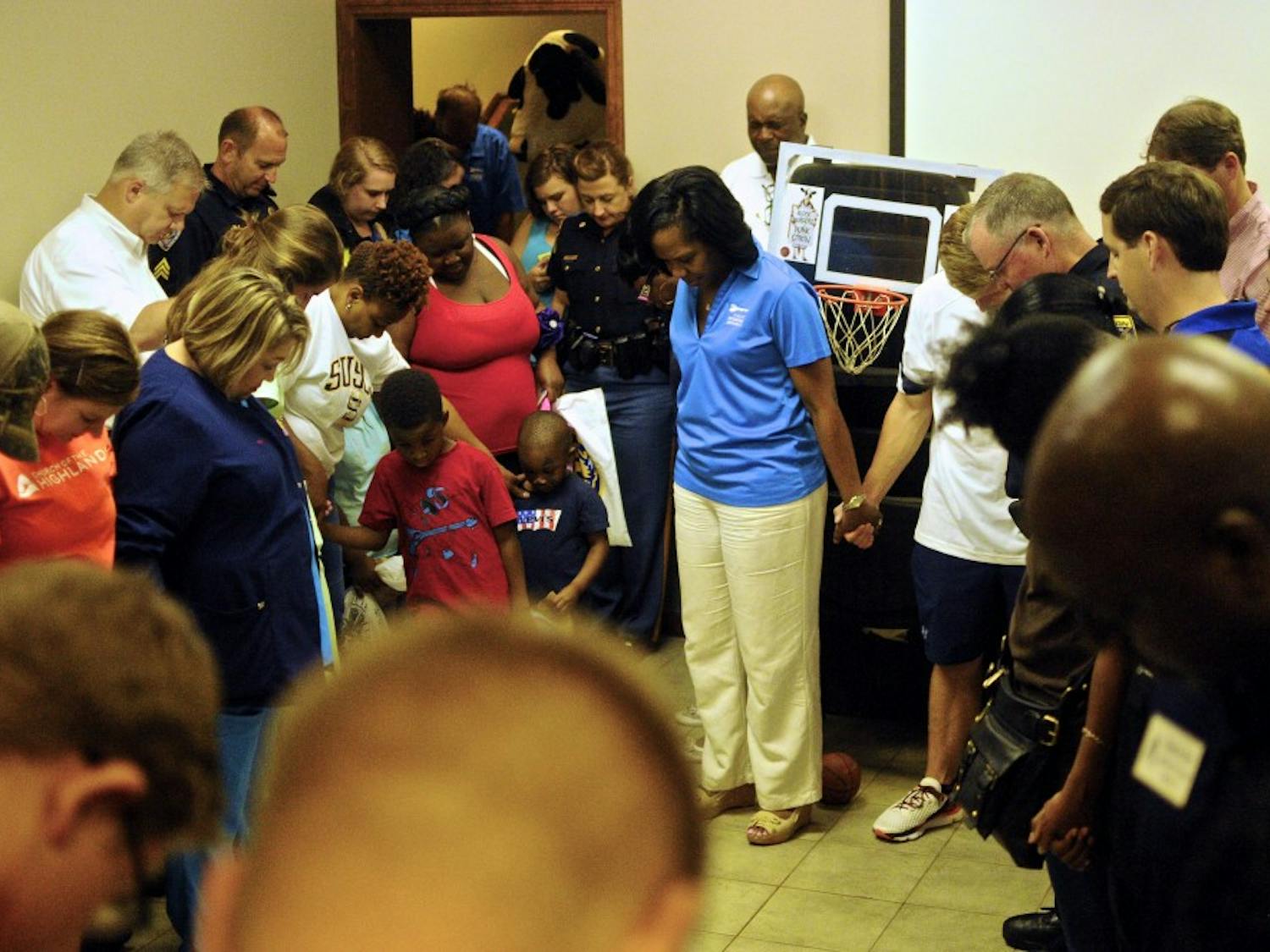 Members of the Auburn community join hands in prayer at National Night Out on Tuesday, August 2, 2016 in Auburn, Ala.