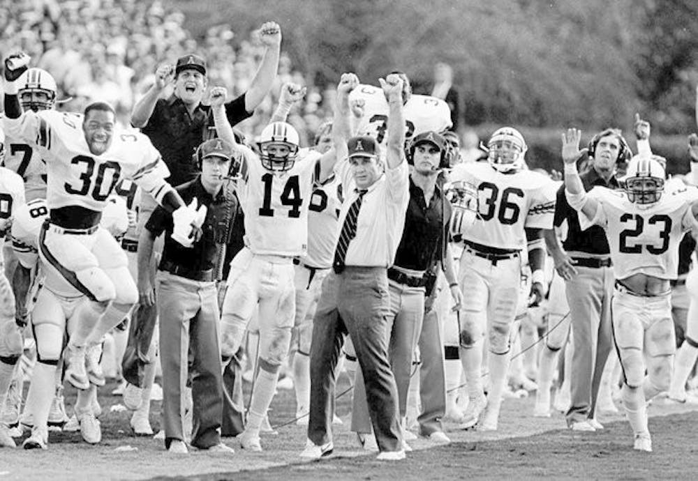 <p>Pat Dye (center) raises his arms in celebration during an Auburn game. (AL.com file)</p>