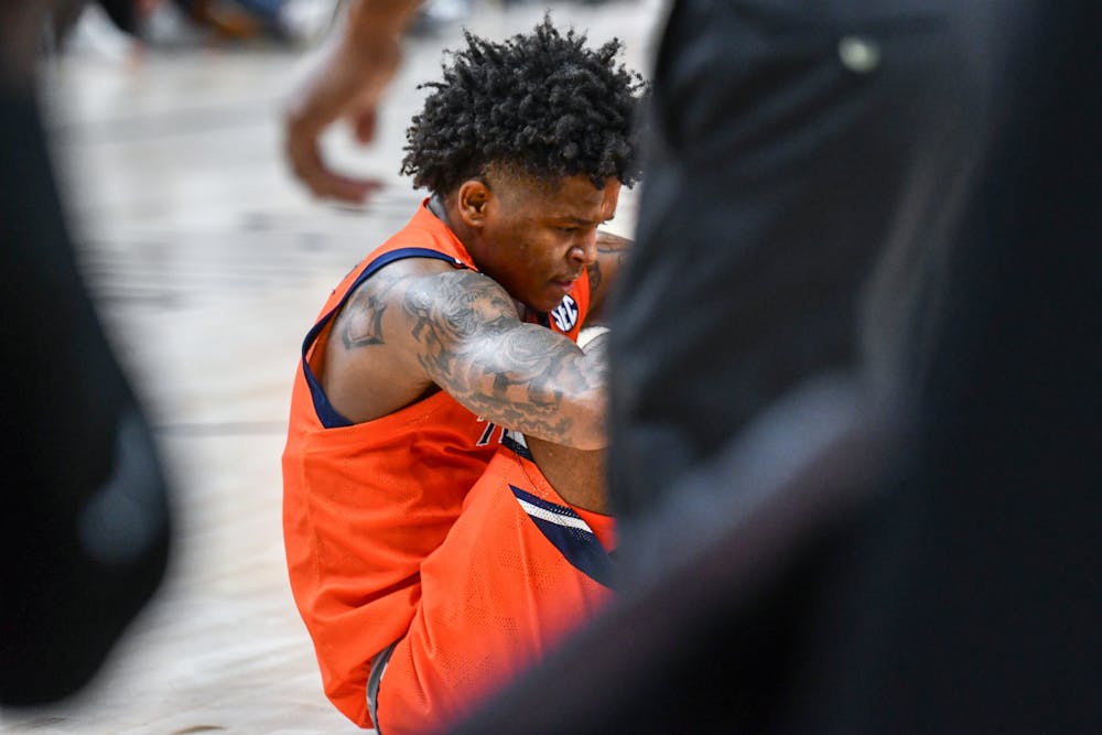 Auburn's Wendell Green Jr. (1) sits on the ground after receiving a foul call in a game against the Memphis Tigers in State Farm Arena on Dec. 10, 2022.