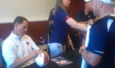 2010 Auburn alumnus Ken Lorang gets his football signed by Gene Chizik. (Andrew Yawn / SPORTS EDITOR)