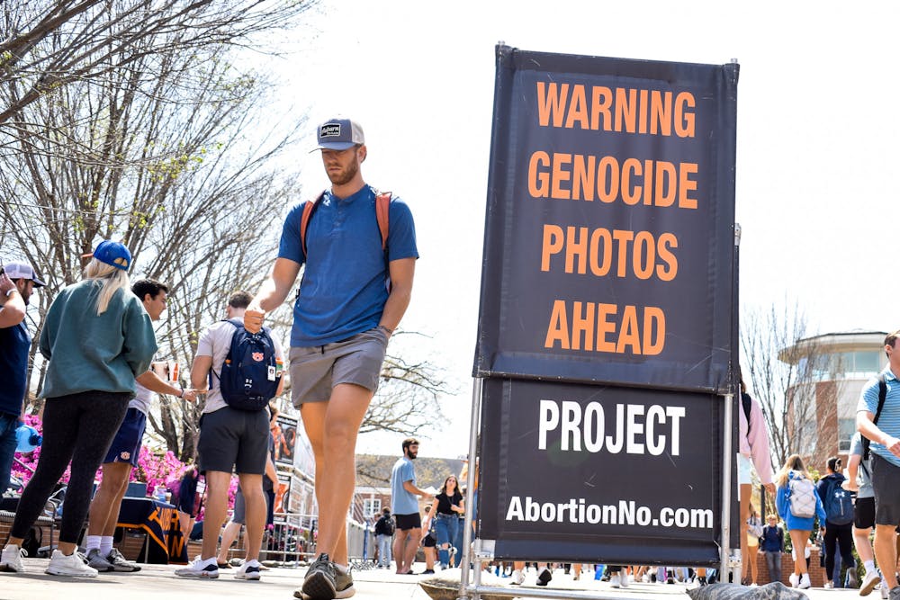 <p>Auburn students and faculty walk past a Pro-Life demonstration on the Auburn University Haley Concourse on March 29, 2022.</p>