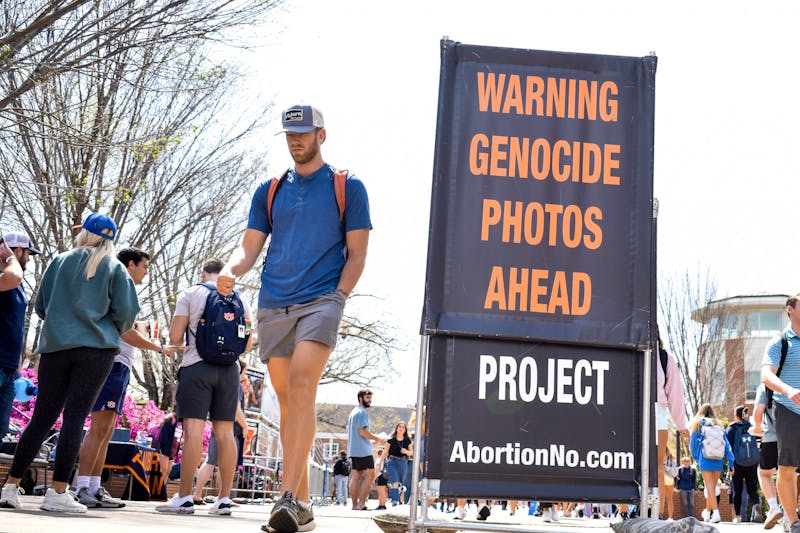 Auburn students and faculty walk past a Pro-Life demonstration on the Auburn University Haley Concourse on March 29, 2022.