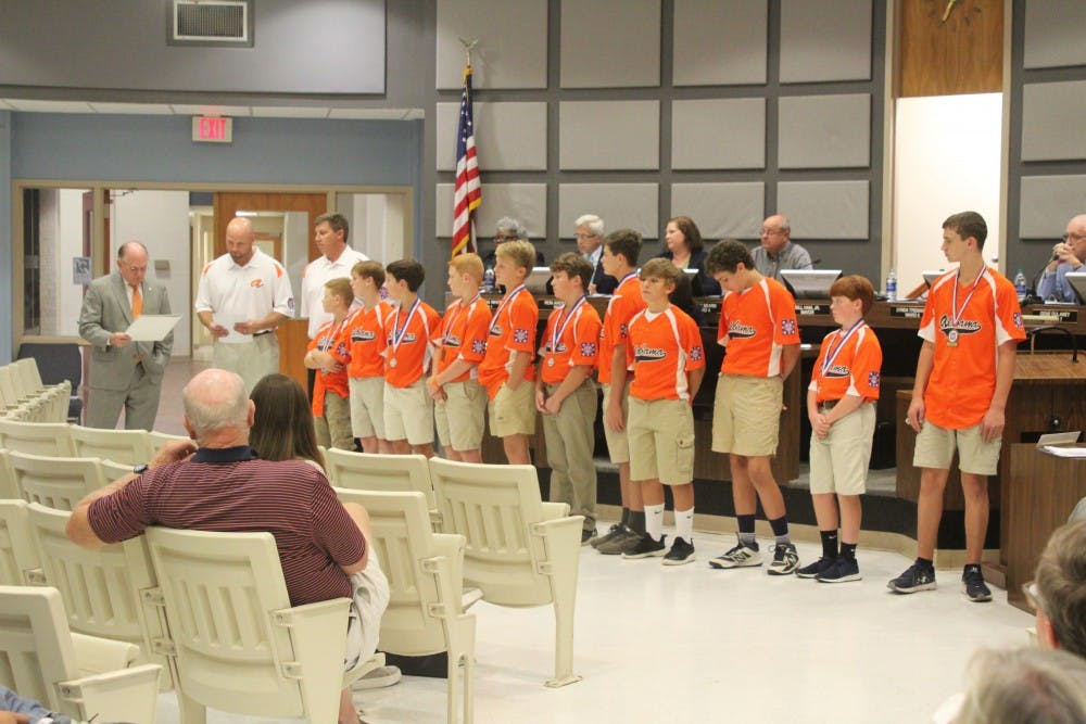 Mayor Bill Ham commends the Auburn Orange Dixie Youth baseball team at the city council meeting on Tuesday, Aug. 21, 2018, in Auburn, Ala.