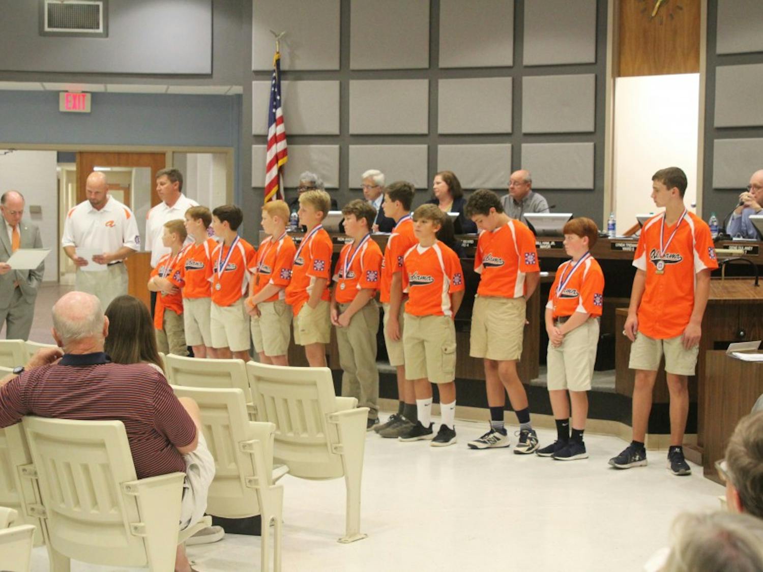 Mayor Bill Ham commends the Auburn Orange Dixie Youth baseball team at the city council meeting on Tuesday, Aug. 21, 2018, in Auburn, Ala.