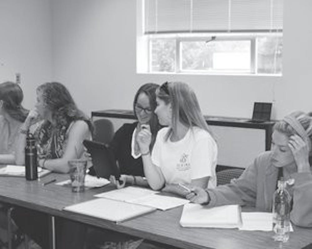 Students of the Hunger Studies class discuss and work over their "Why Care?" awareness campaign. (Emily Morris / ASSISTANT PHOTO EDITOR)