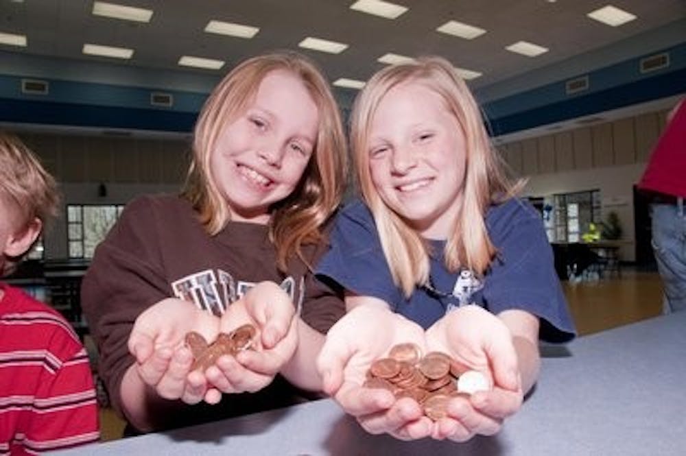 Anna Kate Carter, 9, and Sarah Adams, 10, hold pennies they counted for Haiti during a benefit sponsored by the College of Business. Philip Smith / ASSISTANT PHOTO EDITOR