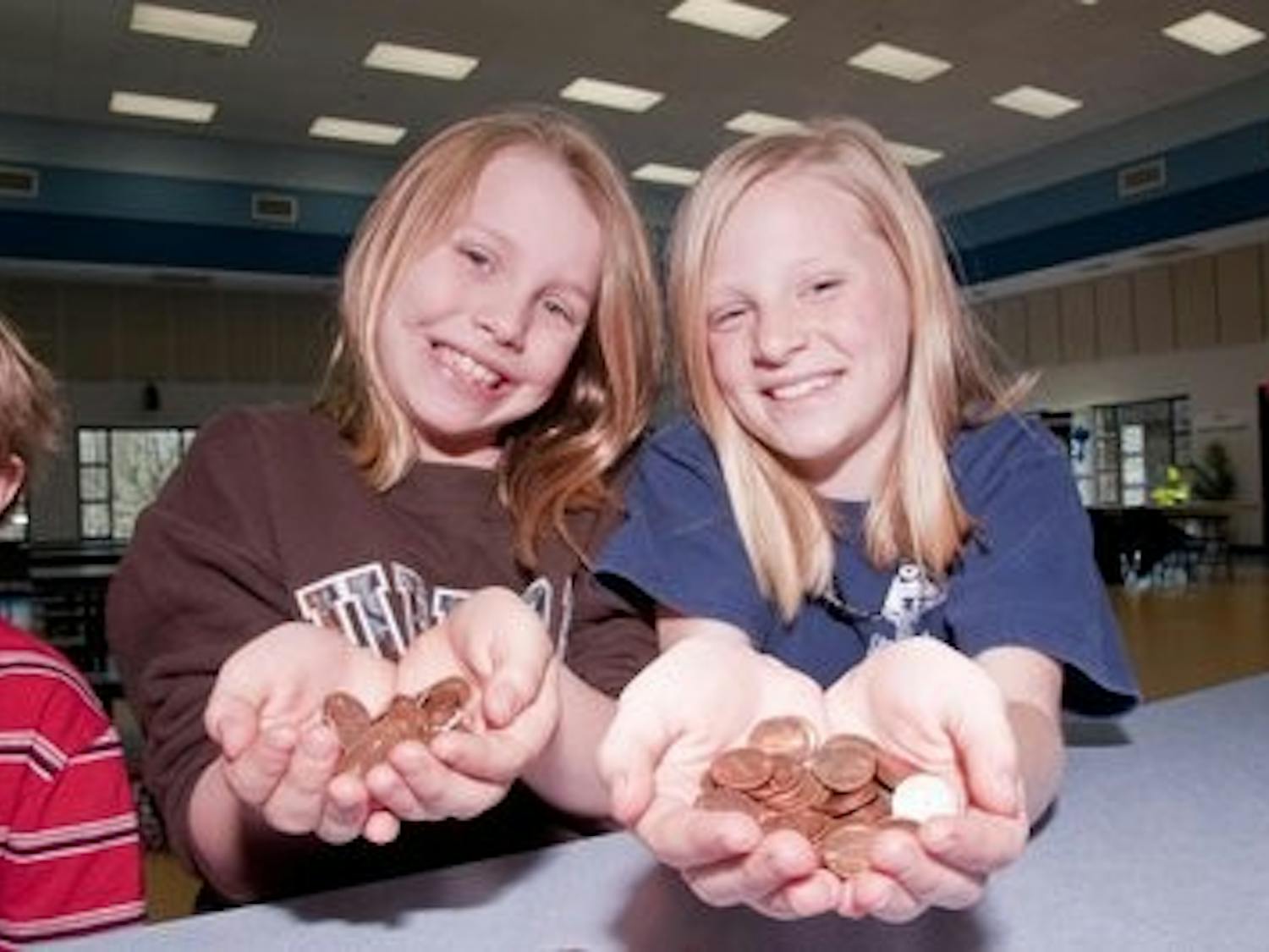 Anna Kate Carter, 9, and Sarah Adams, 10, hold pennies they counted for Haiti during a benefit sponsored by the College of Business. Philip Smith / ASSISTANT PHOTO EDITOR