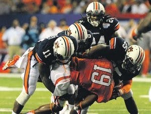 Auburn defenders Chris Davis, Jonathon Mincy and Darren Bates tackle Charone Peake on Saturday. (Courtesy of Todd Van Emst)