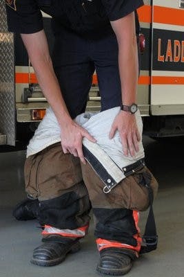 An Auburn student firefighter dons the fire suit in preparation for a call. Students in the Student Firefighter Program are reimbursed for tuition while they work with the fire department. (Alex Sager / PHOTO EDITOR)