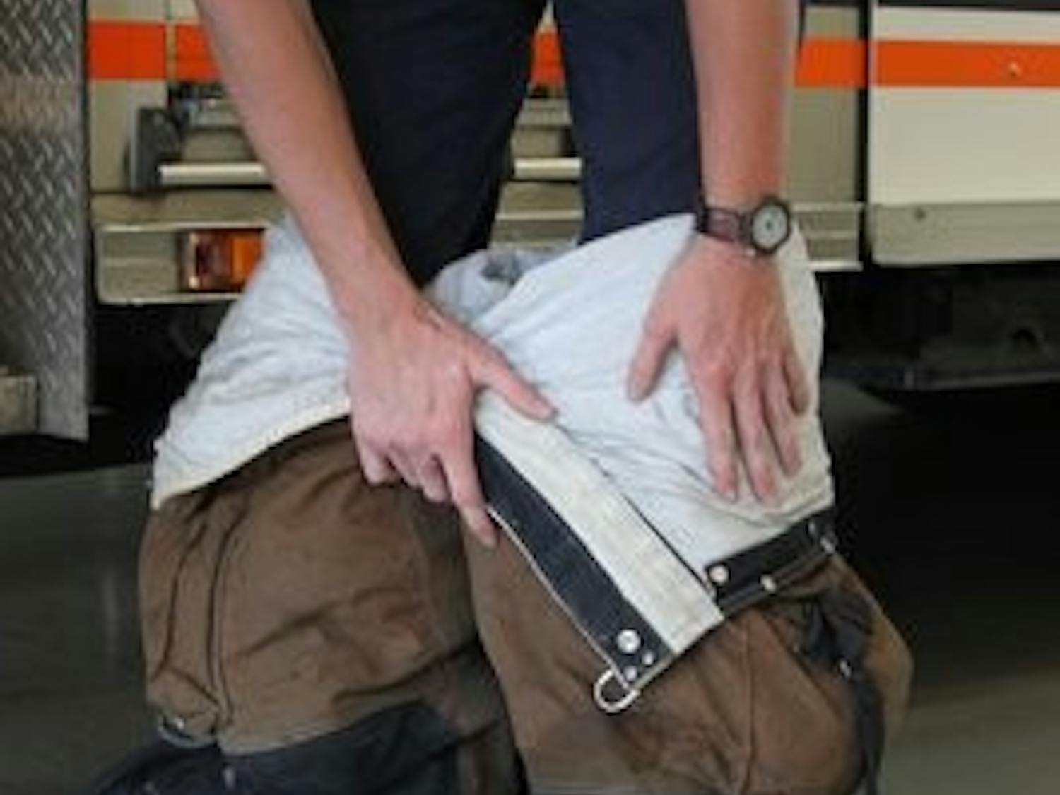 An Auburn student firefighter dons the fire suit in preparation for a call. Students in the Student Firefighter Program are reimbursed for tuition while they work with the fire department. (Alex Sager / PHOTO EDITOR)