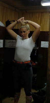 Anna puts her hair up and then covers it with a hair net before she puts on her helmet.