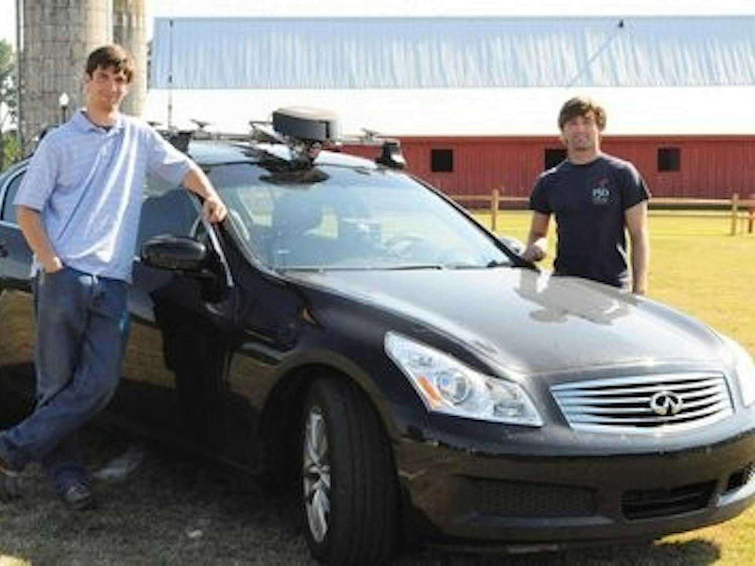 Students john Doe and John Doe stand beside the GPS infiniti G35. (Christen Harned / staff photographer)