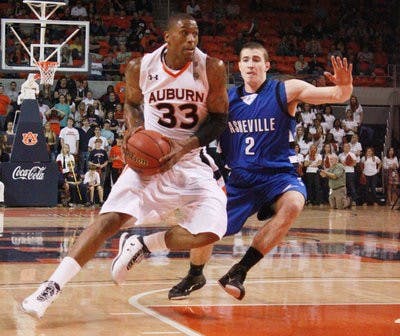Sophomore guard Earnest Ross drives down the court against Asheville guard Matt Dickey. (Emily Adams / Photo Editor)