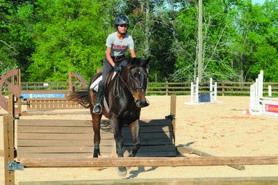 Christina Lin, sophomore hunt seat rider, approaches a jump at equestrian practice Monday. (Christen Harned / ASSISTANT PHOTO EDITOR)