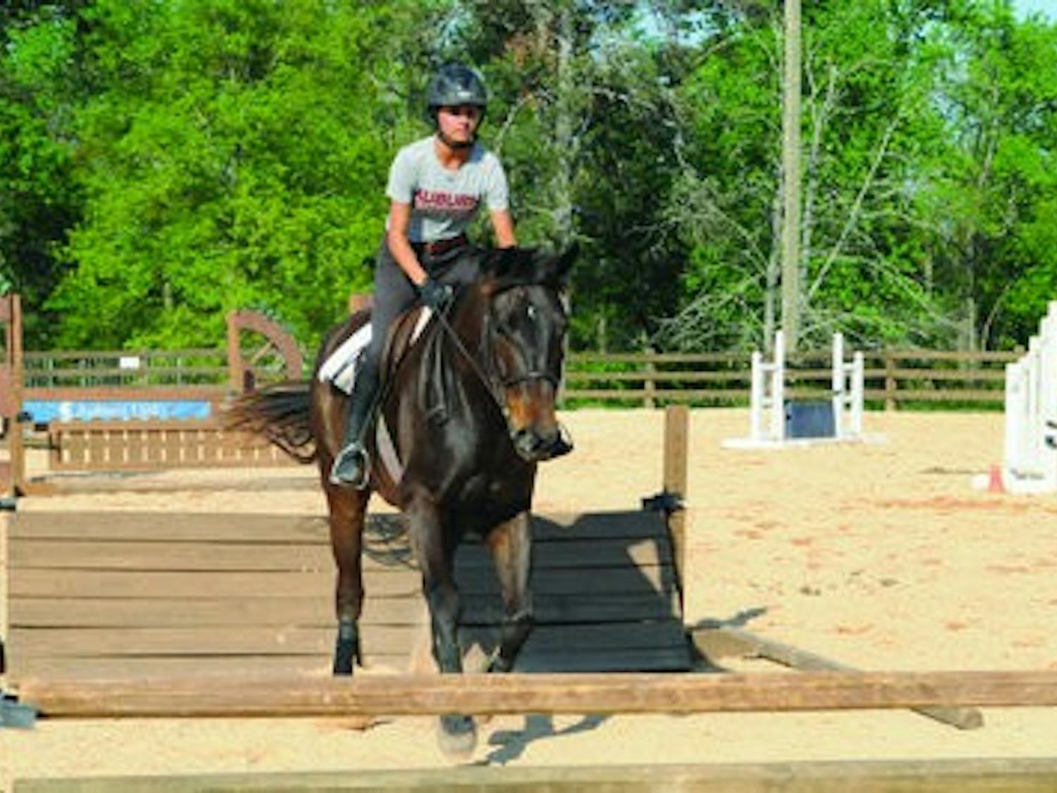 Christina Lin, sophomore hunt seat rider, approaches a jump at equestrian practice Monday. (Christen Harned / ASSISTANT PHOTO EDITOR)
