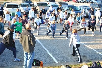 Participants in the 2010 Hunger March, led by the Committee of 19, stretch to prepare for their first day of walking. (Contributed)