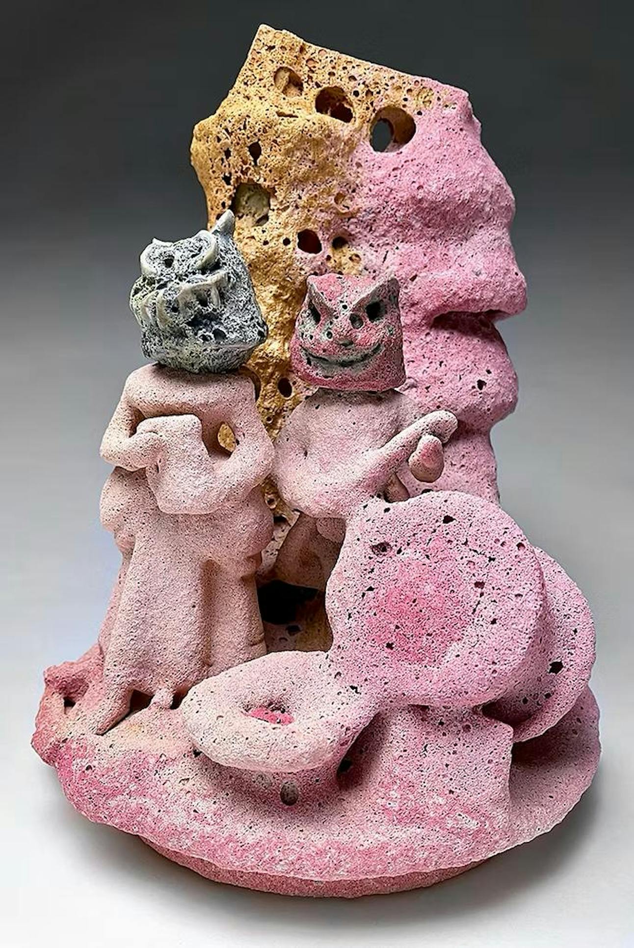 Two figures with monster heads stand on a textured, pink and orange coral-like surface.