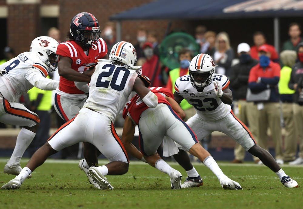 Oct 3, 2020; Oxford, MS, USA; Roger McCreary (23) and Jamien Sherwood (20) get a tackle during the game between Auburn and Ole Miss at Vaught Hemingway Stadium. Mandatory Credit: Todd Van Emst/AU Athletics