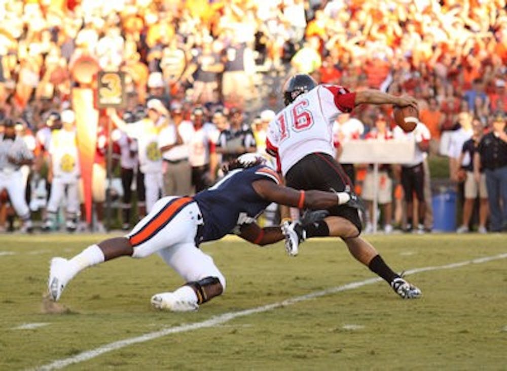 Senior linebacker Josh Bynes brings down Arkansas State quarterback Ryan Aplin. (Emily Adams / PHOTO EDITOR)