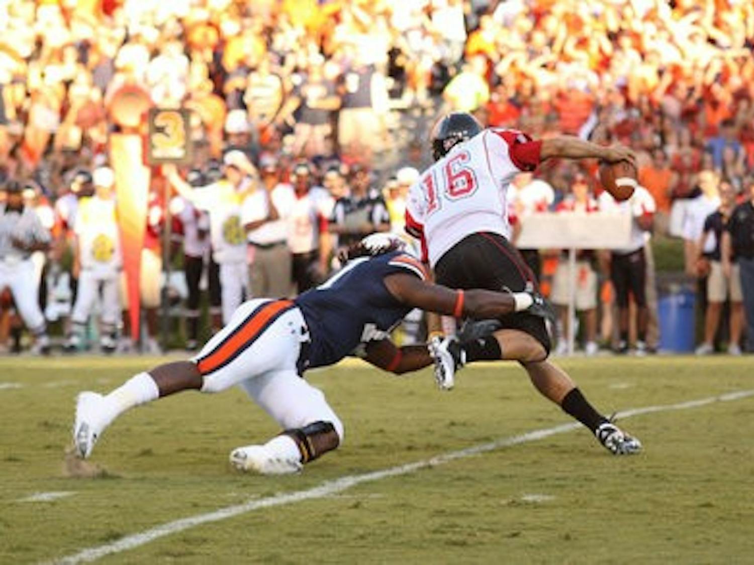 Senior linebacker Josh Bynes brings down Arkansas State quarterback Ryan Aplin. (Emily Adams / PHOTO EDITOR)