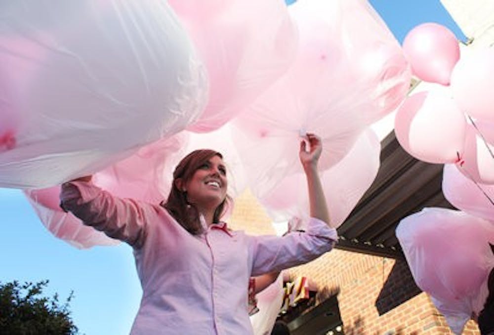 Katie Hicks, store manager, carries bags of pink balloons to be released  into the skies of downtown Opelika Friday. (Emily Adams / Photo Editor)