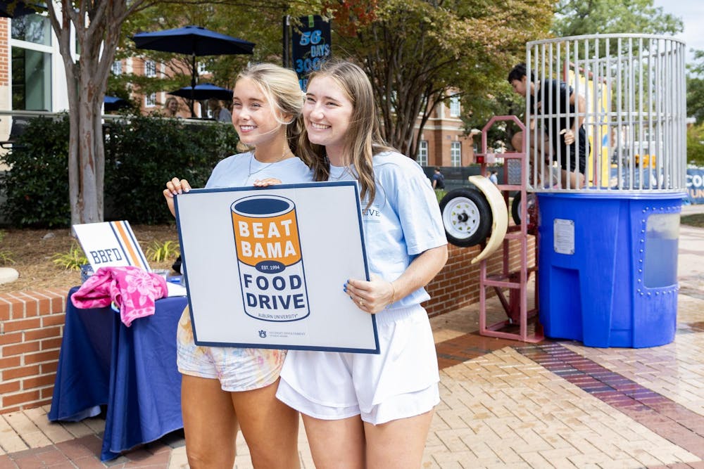 Beat Bama Food Drive committee members pose with a donation sign on the Haley Concourse on October 3, 2025.