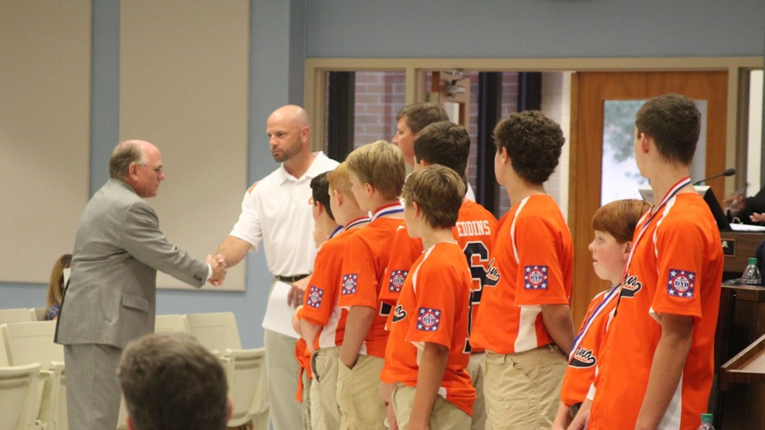 Mayor Bill Ham congratulates the&nbsp;Auburn Orange Dixie Youth baseball team at the city council meeting on Tuesday, Aug. 21, 2018, in Auburn, Ala.&nbsp;