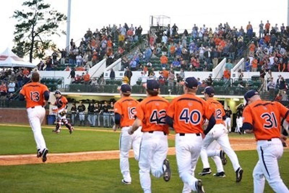 The Auburn baseball team runs onto the field to celebrate its win against Missouri Friday afternoon. The Tigers won the season opener 5--2, but lost the next two games in the series. (Danielle Lowe / ASSISTANT PHOTO EDITOR)