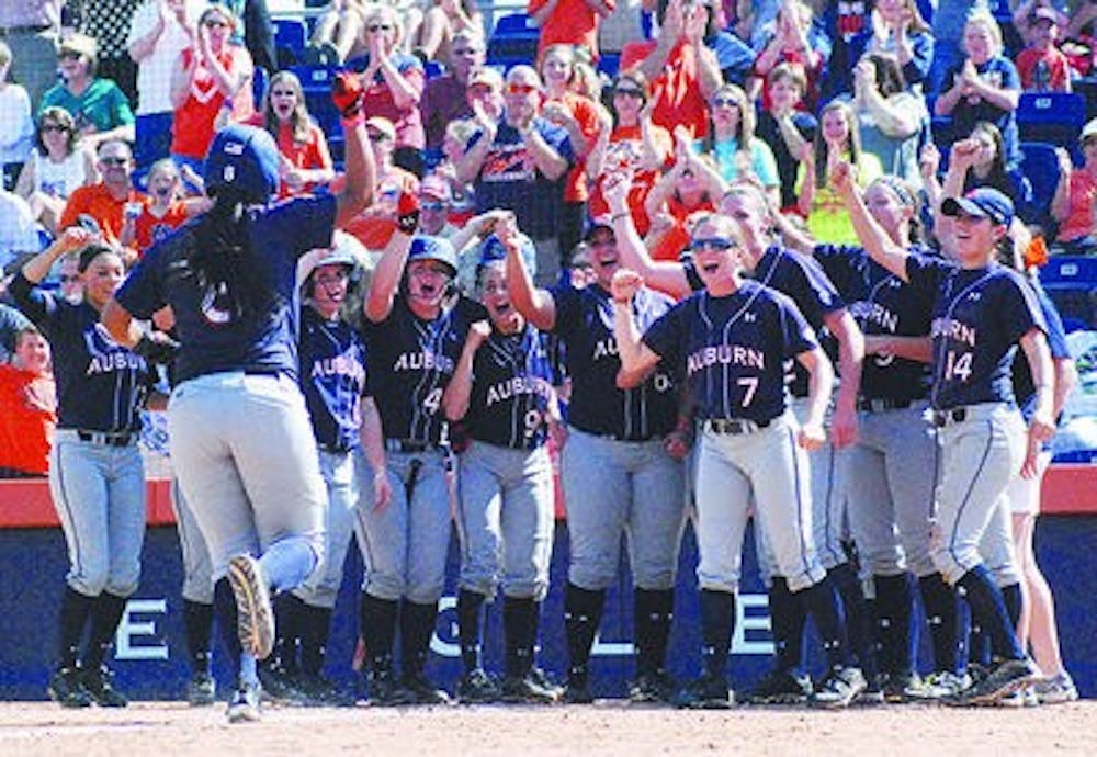 Auburn players celebrate a home run from Jade Rhodes at home plate. (Emily Enfinger / Photographer)