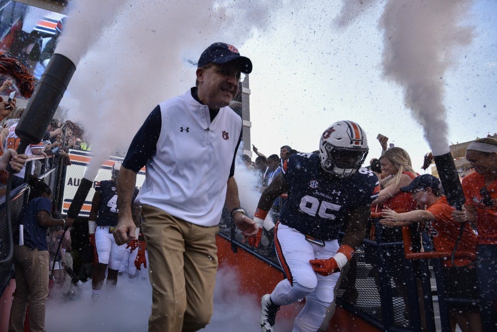 Gus Malzahn and Dontavius Russell (95) enter the field prior to a NCAA college football game, Saturday, Oct. 1, 2016, in Auburn, Ala.