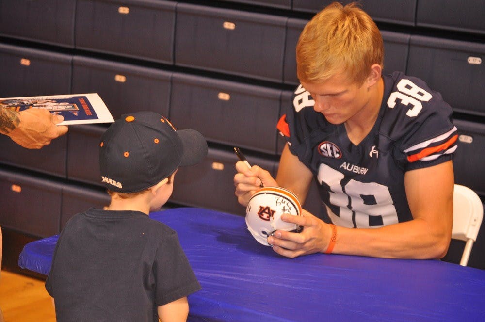 Kicker, Daniel Carlson autographs a fan's football. Anna Grafton / ASSOCIATE PHOTO EDITOR