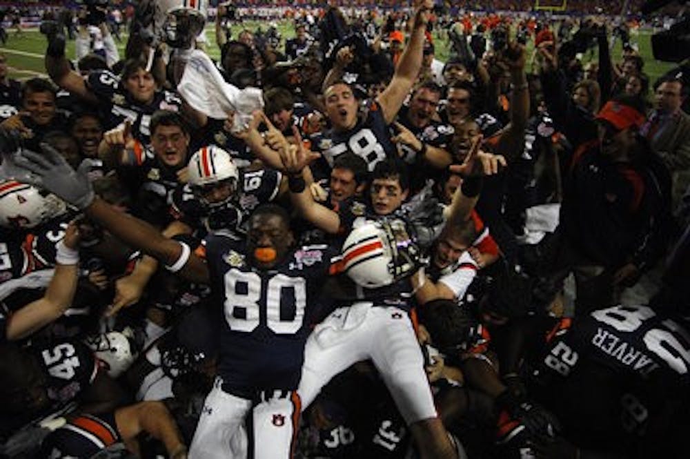 The 2007 Auburn football team celebrates its 23-20 overtime victory against Clemson at the Chick-fil-A Bowl in Atlanta, Ga. Auburn finished the season 9-4. It was Auburn's 19th bowl win. (Todd Van Emst / Auburn Media Relations)