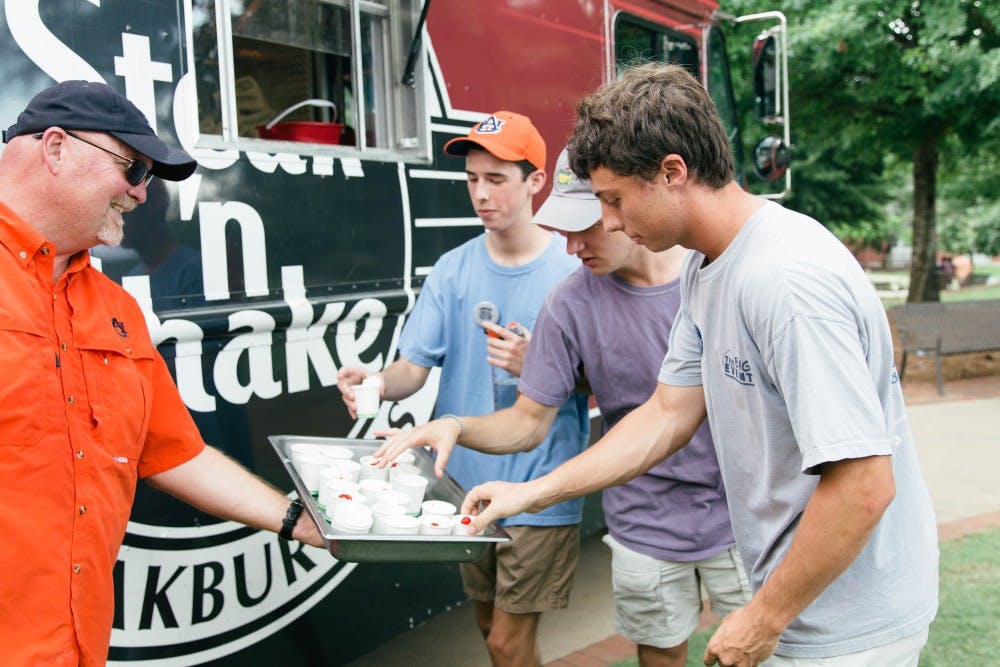 <p>Students pick up mini milkshakes from the Steak 'n&nbsp;Shake food truck during the fall's first Family Friday on Aug. 17, 2018, in Auburn, Ala.</p>