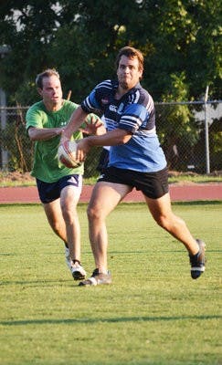 David Bess and Adam Nemeroff play touch rugby at a practice Tuesday, May 29, at the old track and field complex. (Danielle Lowe / PHOTO EDITOR)