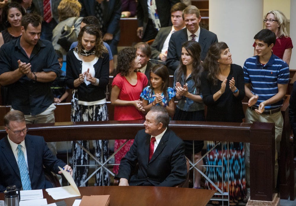 Embattled Alabama Chief Justice Roy Moore gets a standing ovation from supporters as he arrives for his ethics trial at the Alabama Court of the Judiciary at the Alabama Judicial Building in Montgomery, Ala., on Wednesday September 28, 2016.