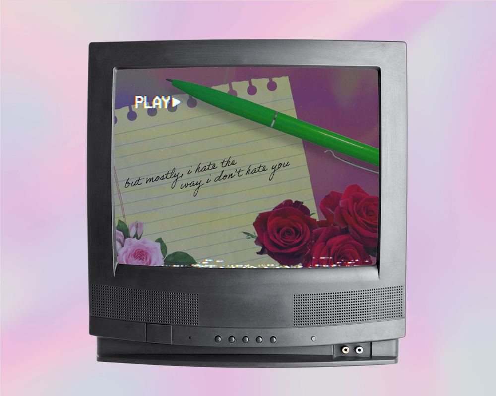 <p>A vintage television displays a notepad with handwritten text and roses, accompanied by a green pen.</p>