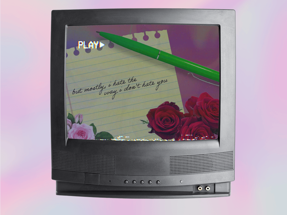 A vintage television displays a notepad with handwritten text and roses, accompanied by a green pen.