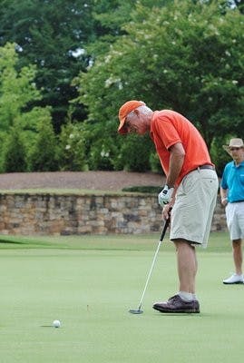 Dean Newschwander putts at Moore's Mill Golf Club during the "Mulligans for Master's" charity event Friday. (Kristen Ferrell / CAMPUS EDITOR)