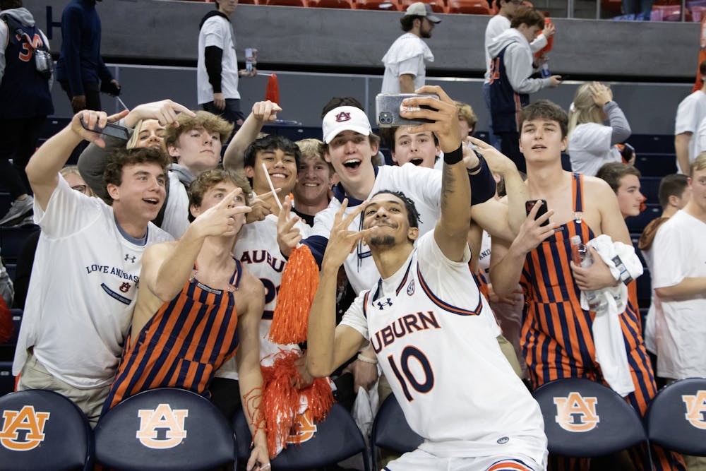 Chad Baker-Mazara (#10) poses for a selfie with students following Auburn's win over South Carolina in Neville Arena on February 14th, 2024.